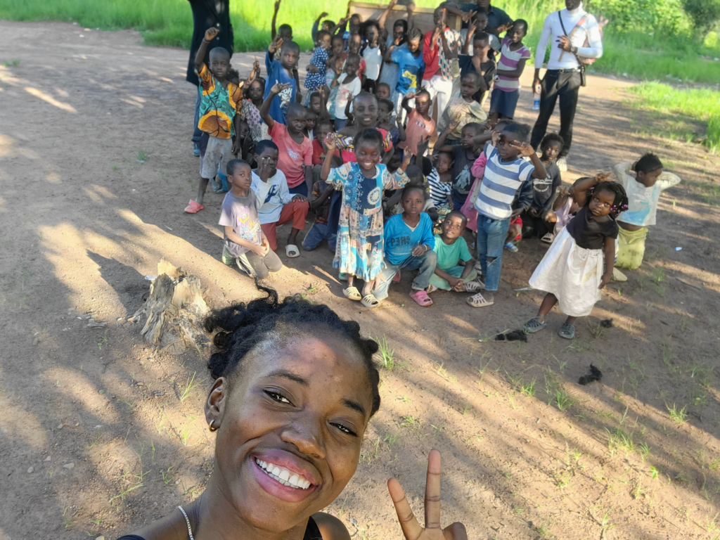 Ntumba with children from the community gathered behind her in the Democratic Republic of Congo
