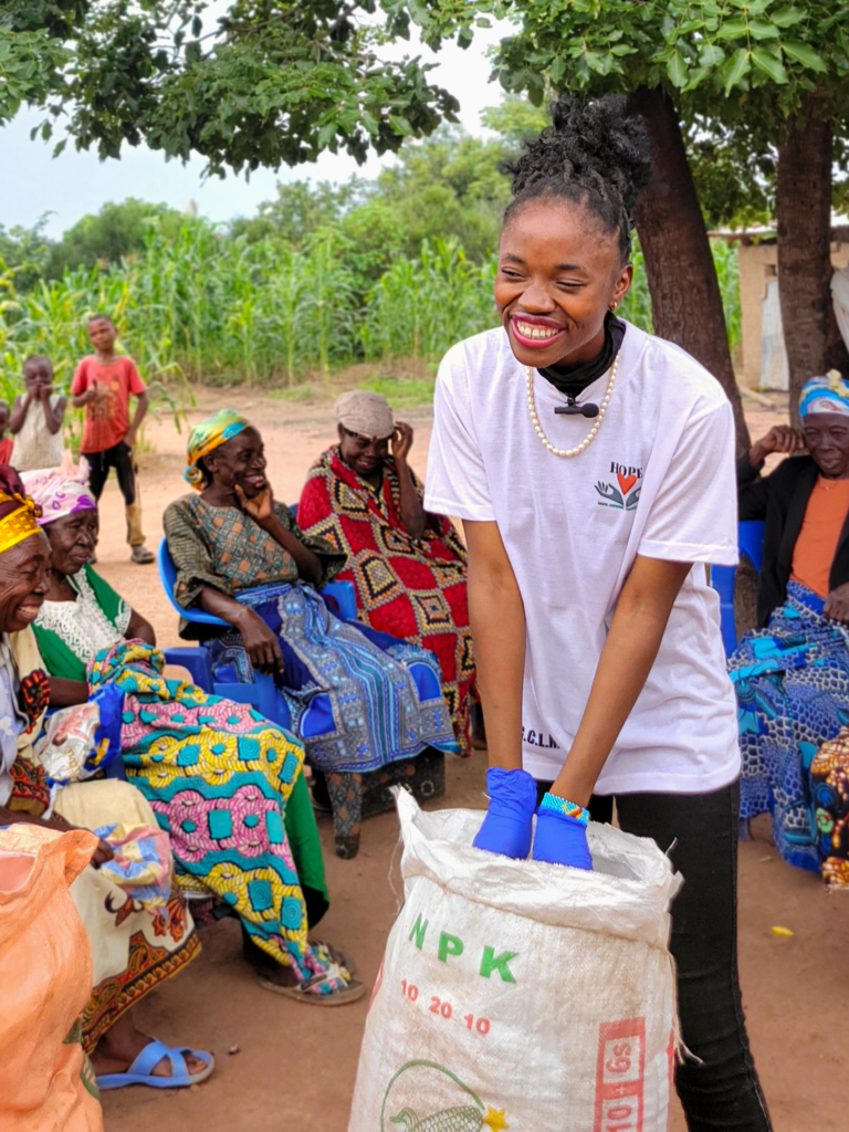 Widows receiving sacks of NPK fertilizer from a Hope G.C.L.M. team member