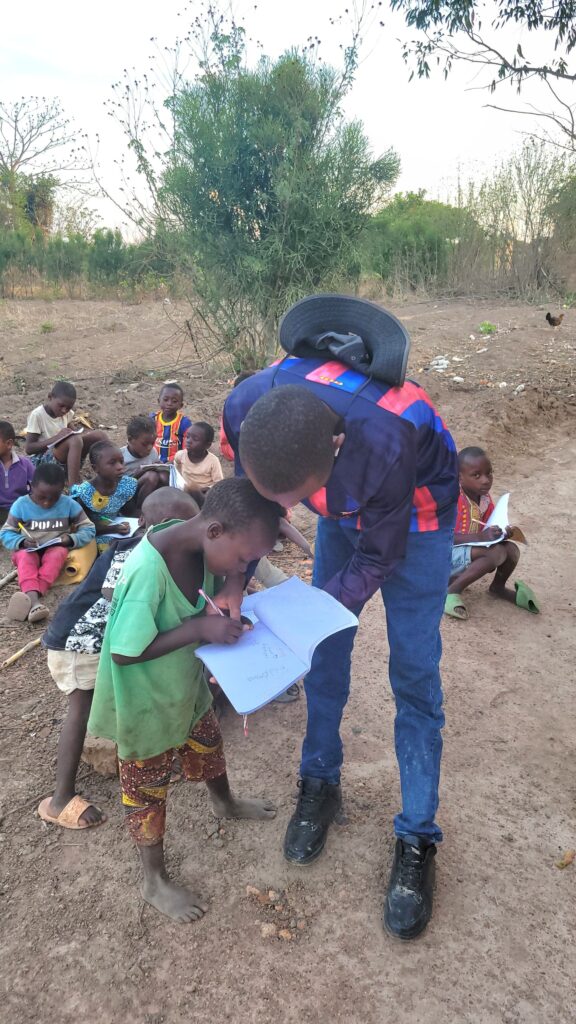 Volunteers teaching children outdoors with the Hope G.C.L.M. Foundation in the Democratic Republic of Congo