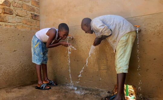 Children collecting clean water at a tap installed by Hope G.C.L.M.